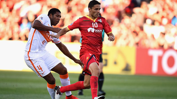 Adelaide's Marcelo Carrusca harassed by Shandong's Jucilei.